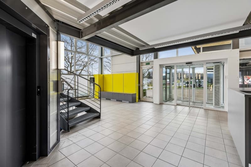 modern building, tiled floor, glass doors, staircase, yellow cabinets, large windows