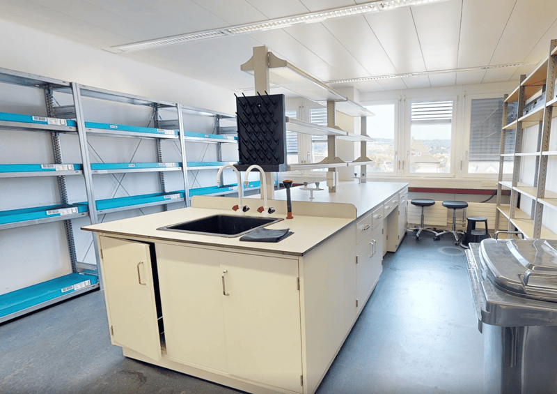 laboratory with cabinets, sink, countertop, shelves, and stools