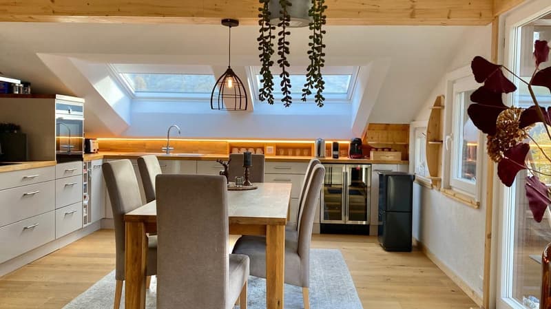 kitchen with dining area, wooden floor, wooden table with chairs, white cabinets, modern faucet, refrigerator, coffee machine, hanging plant, skylight windows, view of outside