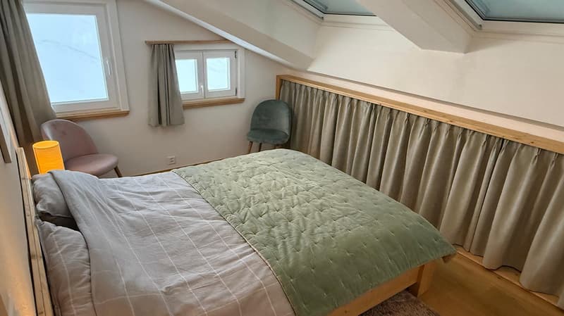 bed, pillows, duvet, rug, desk lamp, 2 chairs, 2 windows, curtains