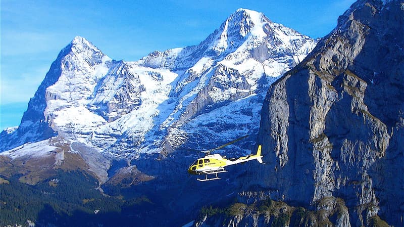 Helicopter flying over snowy mountains