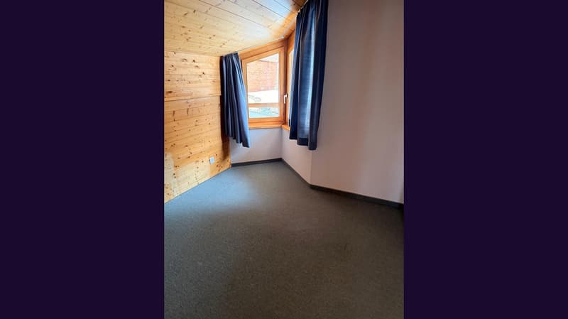 empty room, wooden wall, carpeted floor, window with blue curtains