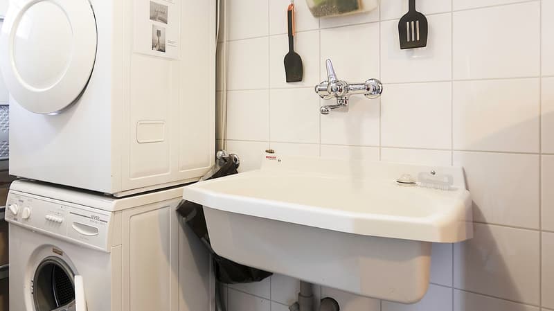 Laundry room with washing machine, dryer, sink, and utensils