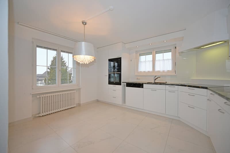 modern kitchen, white tiles, white cabinets, black granite countertops, chandelier, oven, dishwasher, window with curtains