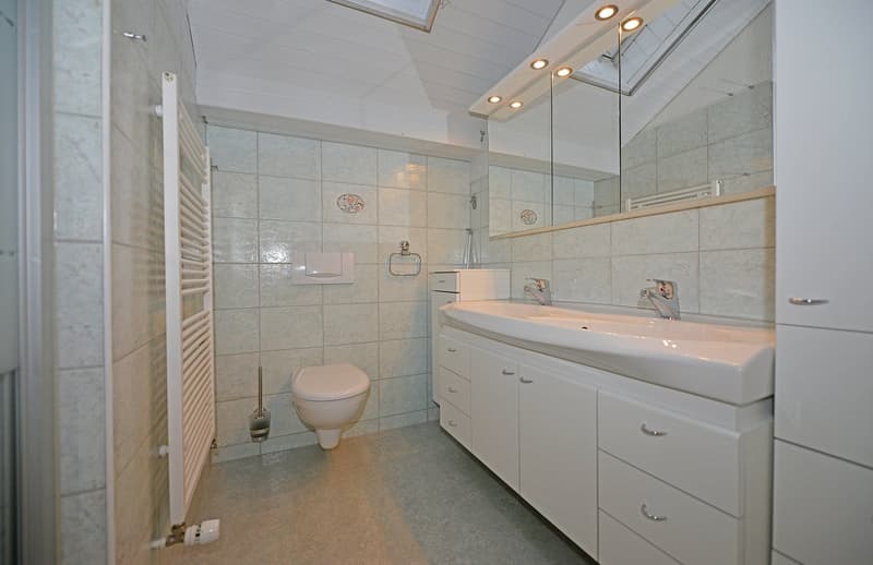 modern bathroom with white tiles, toilet, bidet, sink, mirror, cabinets, white washing machine