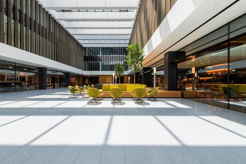 Spacious open space, modern design, marble floors, yellow furniture, tall ceilings, windows and doors