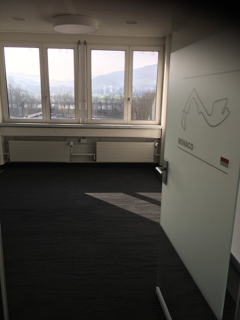 Large windows, view, black floor, white walls, Monaco sign on door