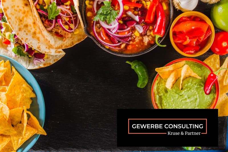 Mexican food such as tacos, salsa, chips, guacamole, soup, vegetables, garlic and chili peppers