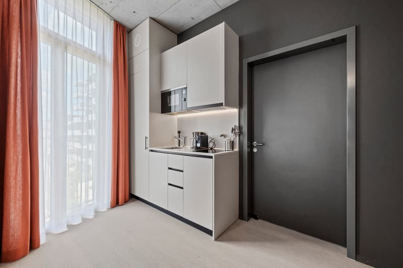 white kitchen, sink, faucet, coffee maker, black countertop, microwave, curtains
