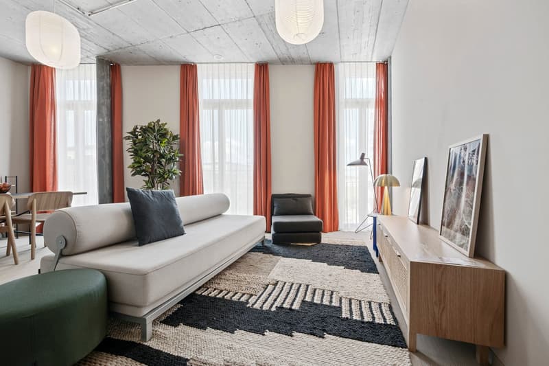 Modern design, large windows, indoor plants, contemporary furnishings, abstract artwork, minimalist aesthetic.