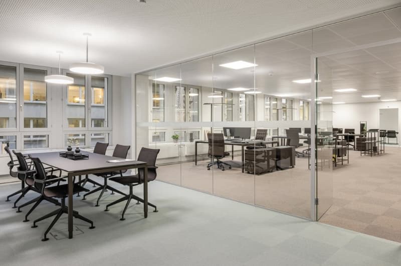 modern office space with glass walls, desks, and chairs