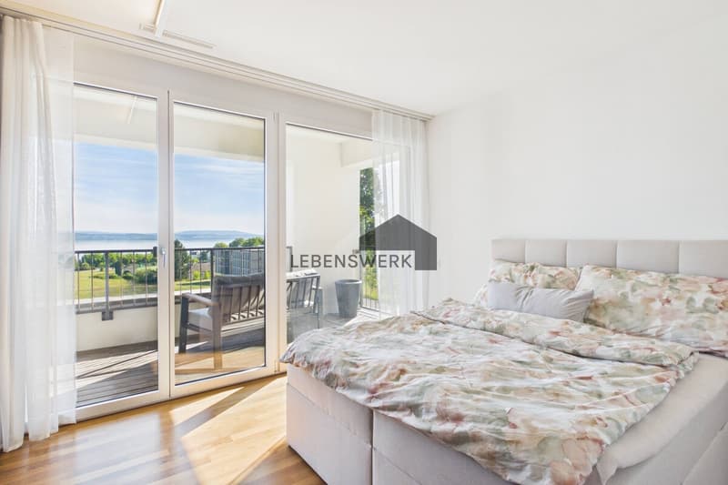 Helles Schlafzimmer mit direktem Balkonzugang sowie Masterbad und traumhaftem Blick auf den Bodensee.