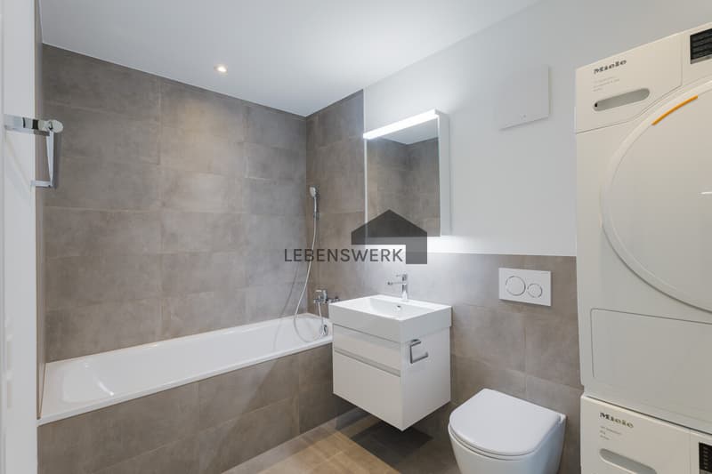 Modernes Badezimmer mit Badewanne und praktischer Waschturm-Lösung  komfortabel und funktional gestaltet.