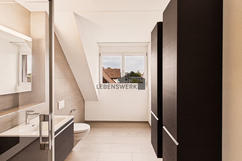 Tageslichtbad mit Dusche und modernen Badmöbeln