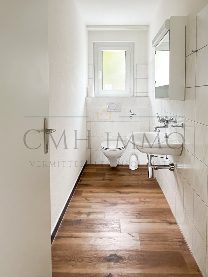 small bathroom with toilet, sink, and window