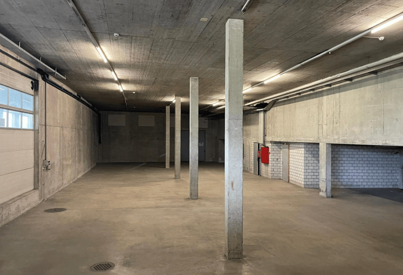 Empty garage space with concrete pillars and concrete floor