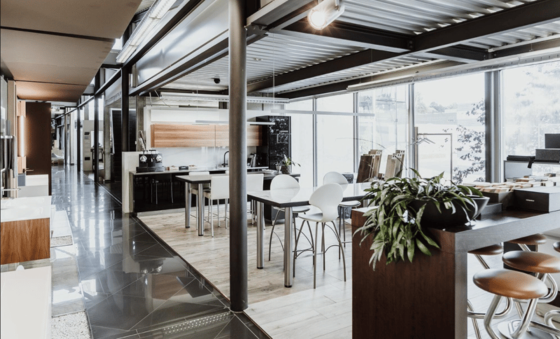 modern kitchen, white tile floor, black countertops, white cabinets, white chairs, white table, metal beams, industrial lighting