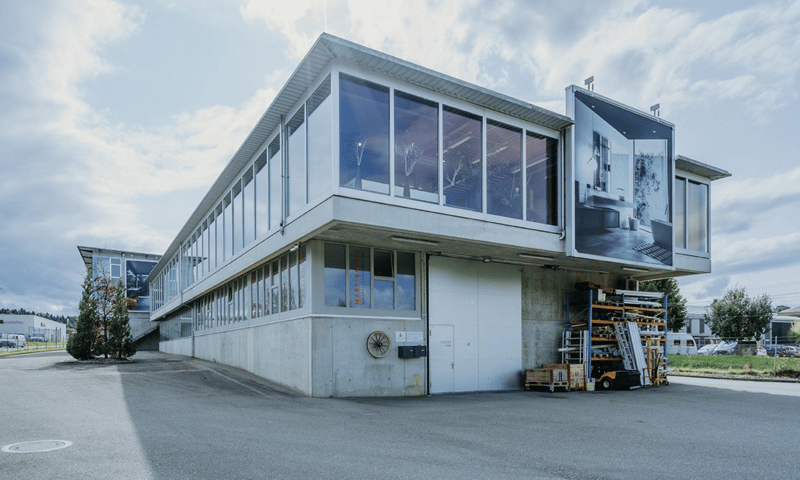 modern office building with large windows, two stories, white exterior, open parking area