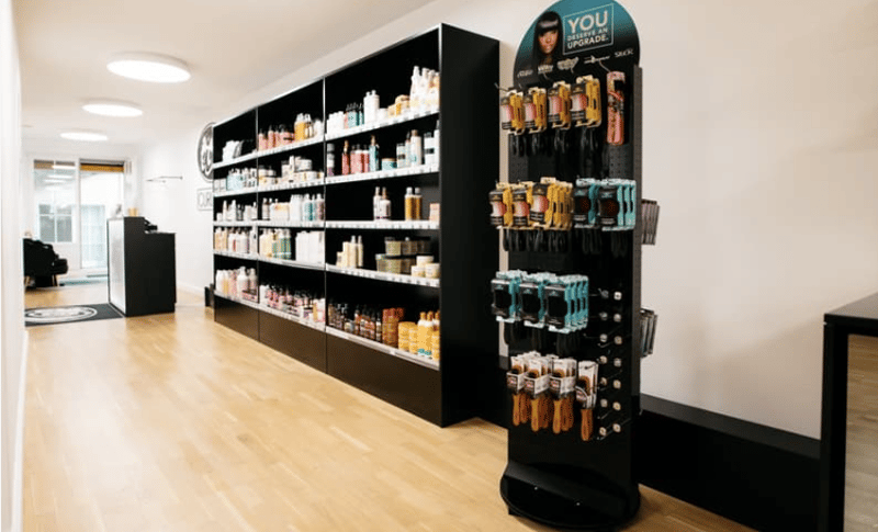 Hair salon with shelves full of products and tools, wooden floor