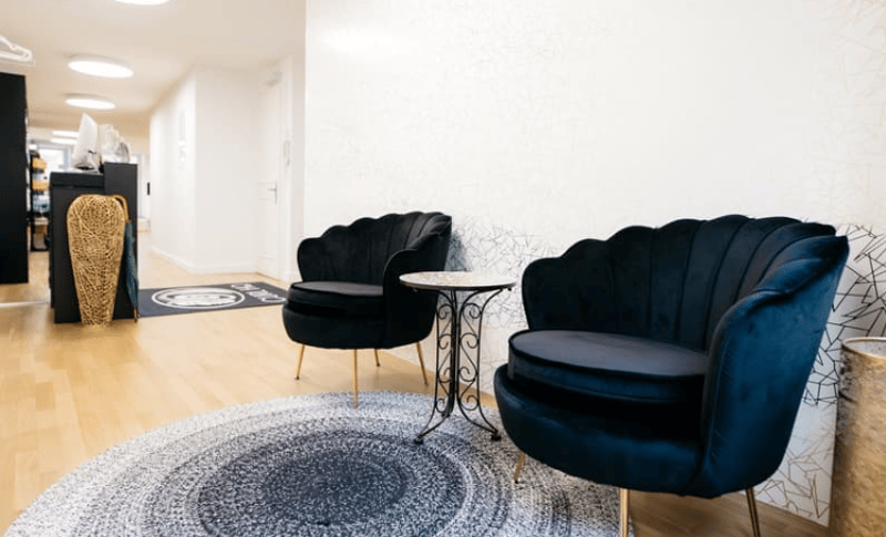 Two velvet armchairs, round rug, small round table, basket, hallway, white walls