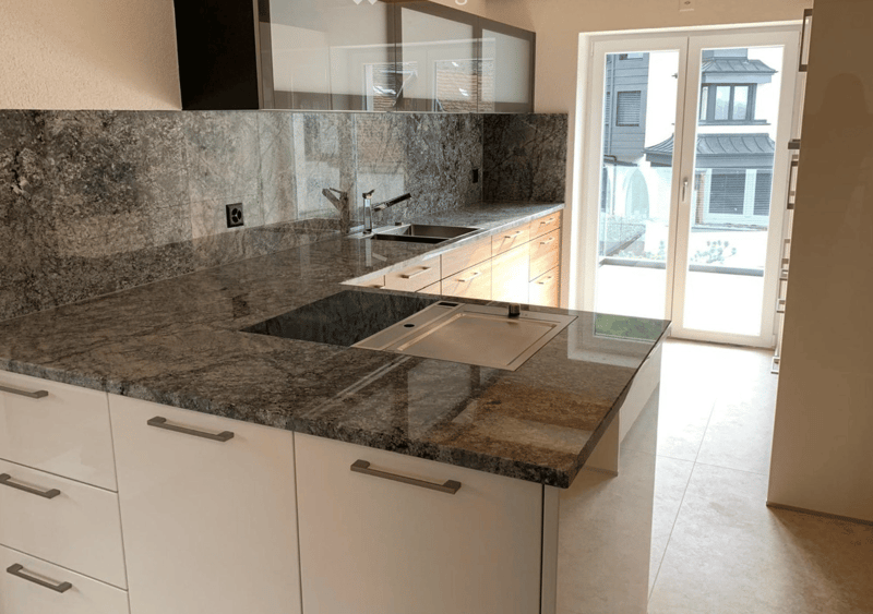 modern kitchen with granite countertops, stainless steel sink, faucet, white cabinets, tile flooring, sliding glass door, exterior view