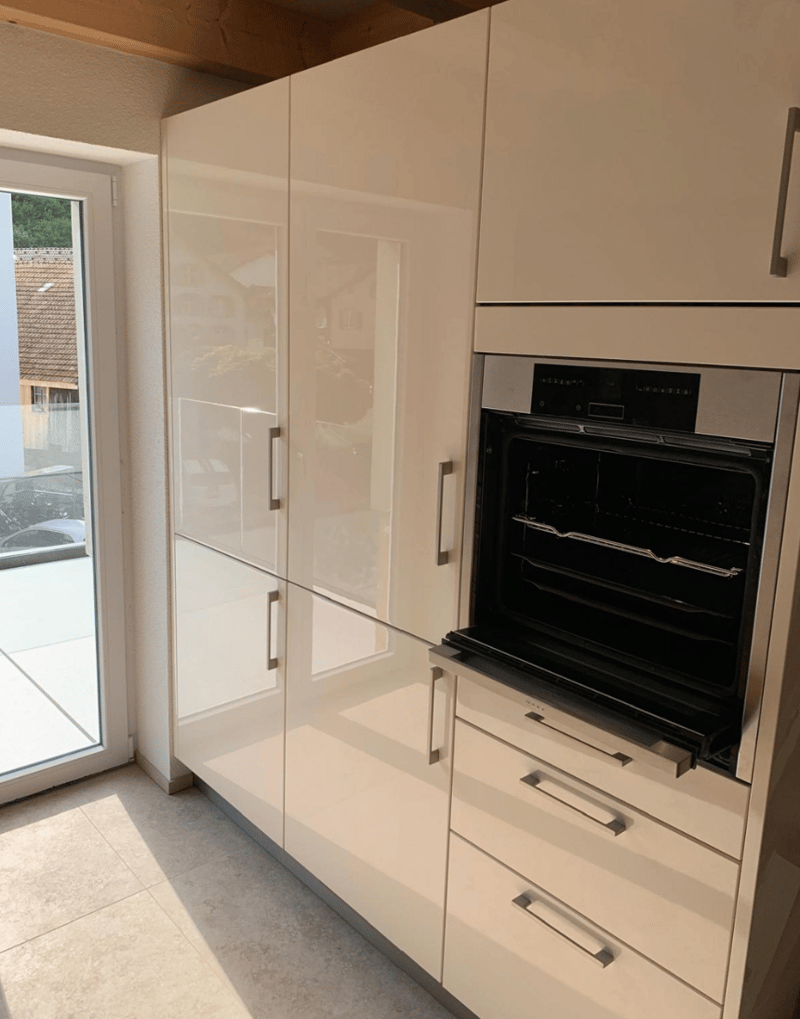 modern kitchen with white cabinets, glass door, open oven, and white tiled floor