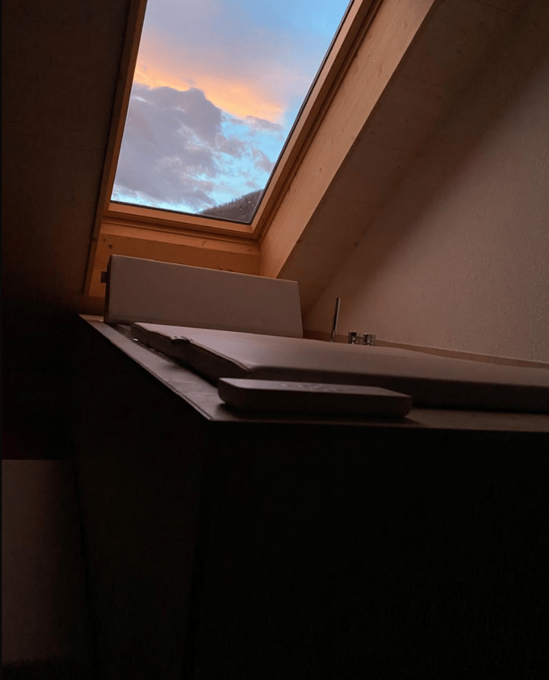 bathroom with bathtub, glass window, wooden wall, daylight
