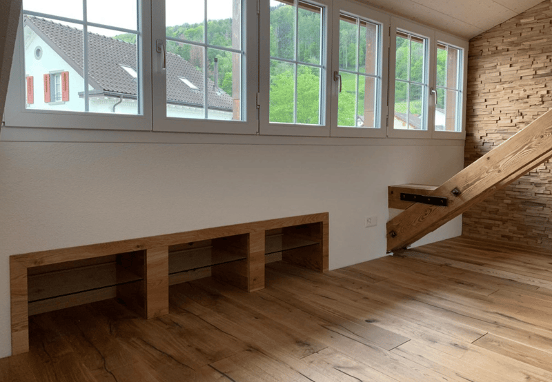large windows, wood floor, wall-mounted shelves, brick wall, staircase