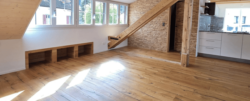 room with wooden floors, white walls, a wooden ladder, built-in bench, kitchen and large windows