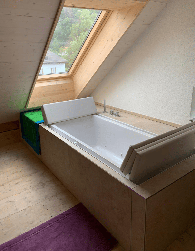 wooden ceiling, bathtub, sink, window, tiled wall, purple rug, towel