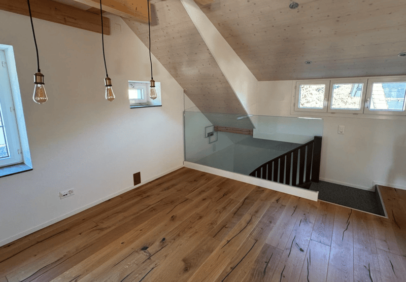 wooden floors, glass wall with railing, two small windows, two lights