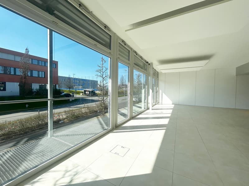 large windows, white tile floor, white walls, metal grates on windows, view of outside