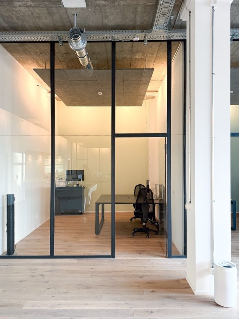 modern office, glass walls, hardwood floors, open layout, two office desks, black office chairs, monitors, cabinet, minimalistic