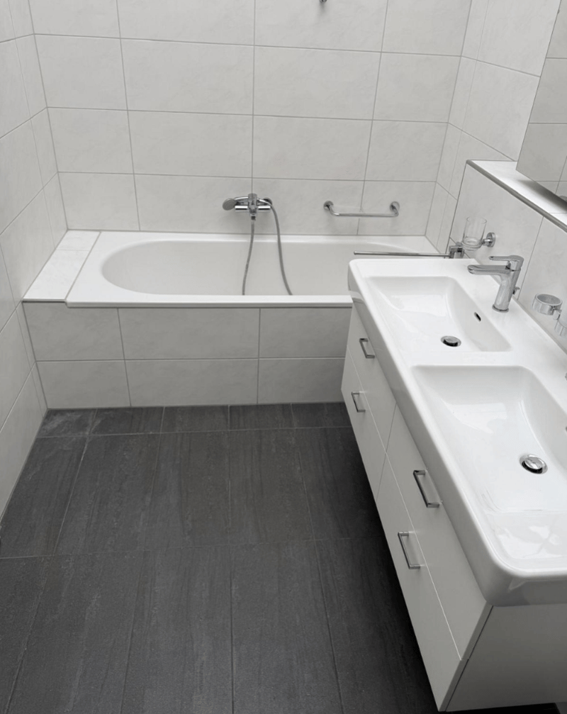modern bathroom, white tiles, white bathtub, white sink, white vanity with drawers, modern faucet