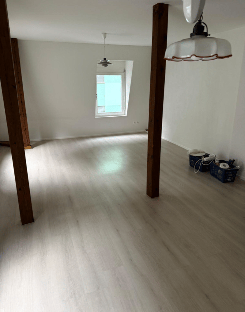 empty room with wooden beams, wooden floor, 2 windows, ceiling lamps