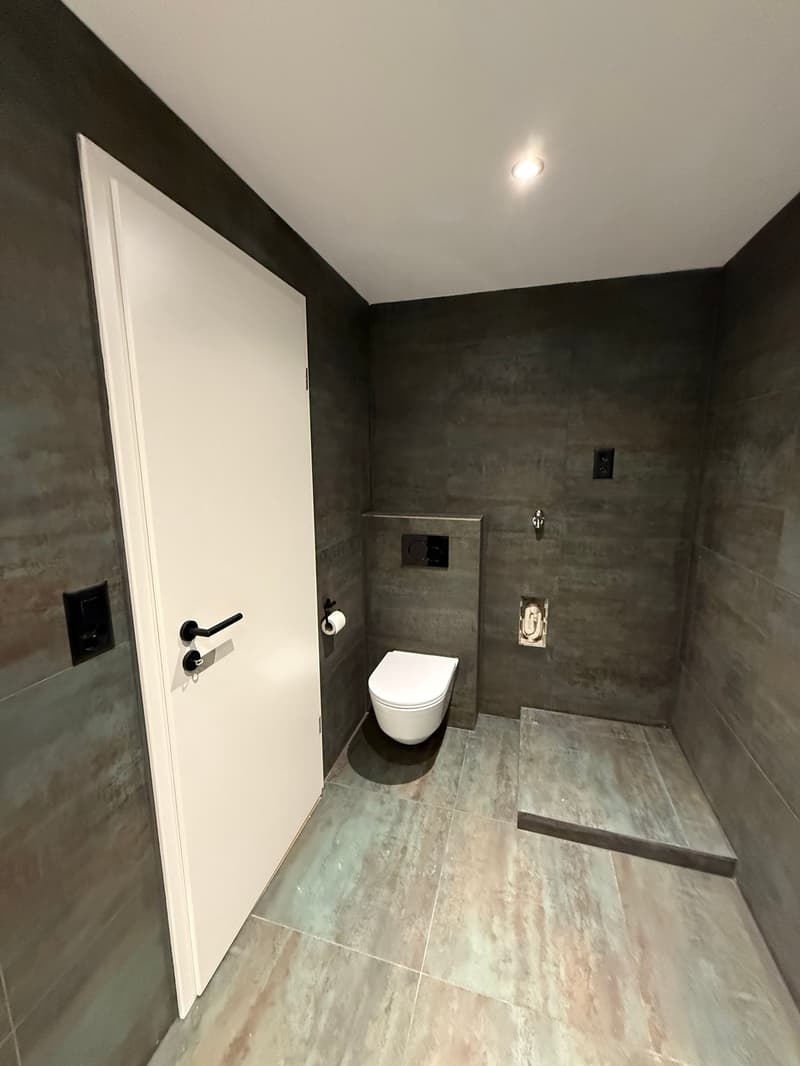 small bathroom with toilet, shower, and tiled floor