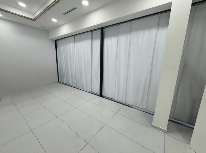 empty room with white tiled floor, white walls, sliding glass doors, and white curtains