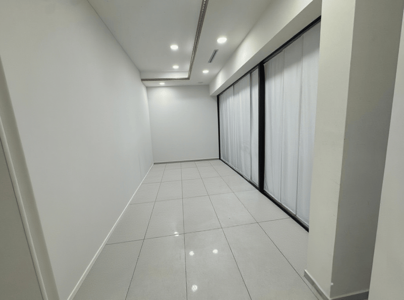empty hallway with white walls, black sliding doors, recessed lighting, tiled floor