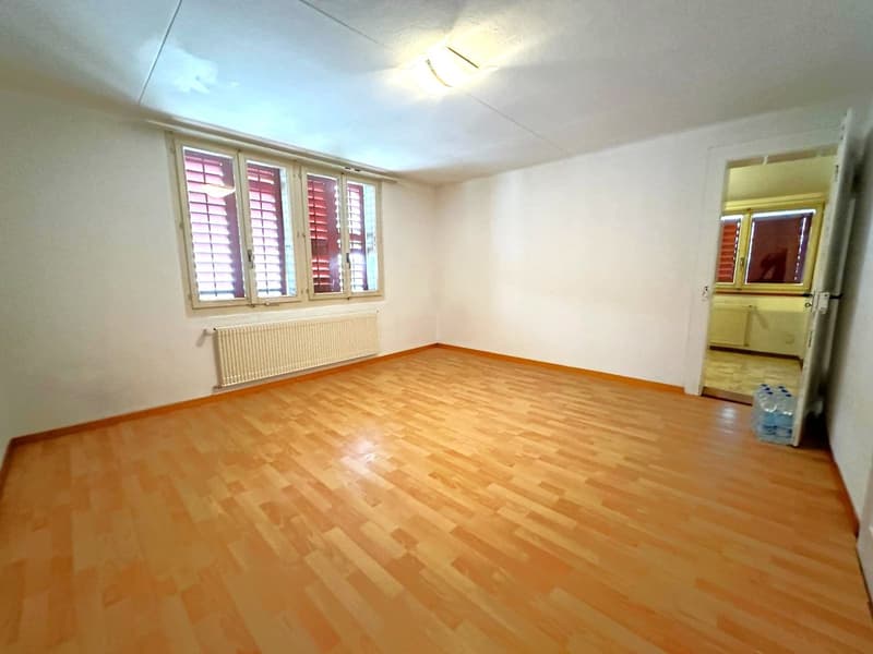 empty room, wooden floor, white walls, windows with shutters, radiator, open door