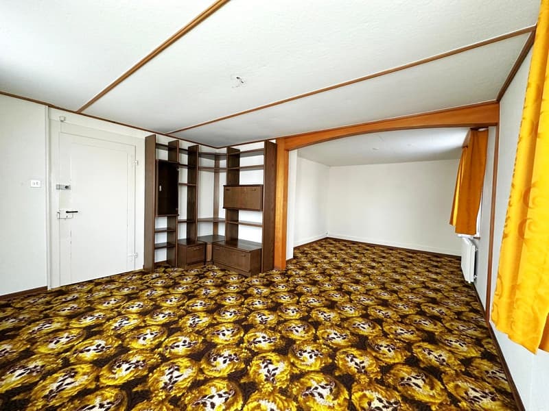 empty room, wooden shelves, white door, yellow carpet, white walls