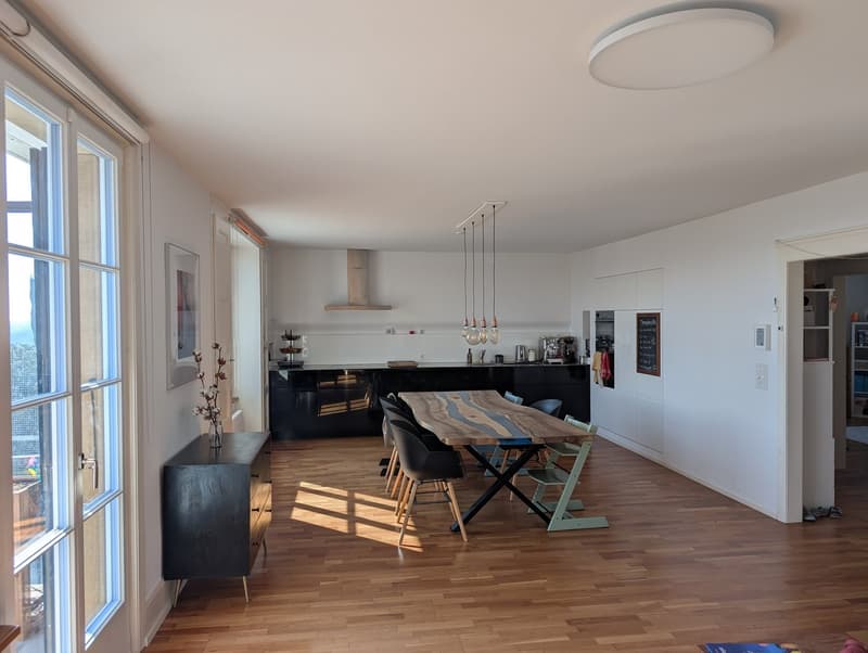 modern kitchen with dining area, wooden floor, large windows, wooden table, black chairs, black cabinet, modern lighting