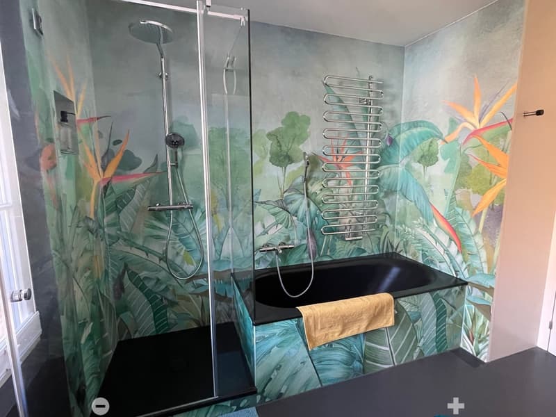 shower area with glass door, bathtub, towel, tropical wallpaper