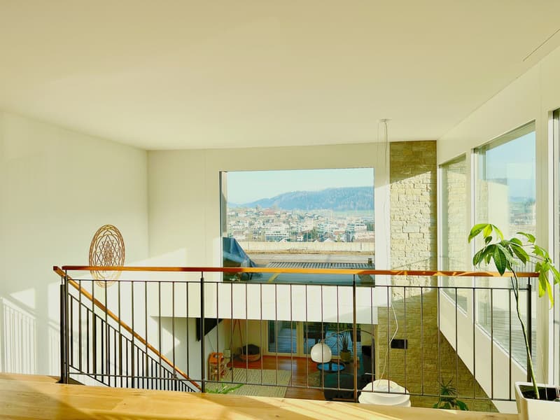 balcony with railings, large windows, view of the city, hanging lamp, potted plant