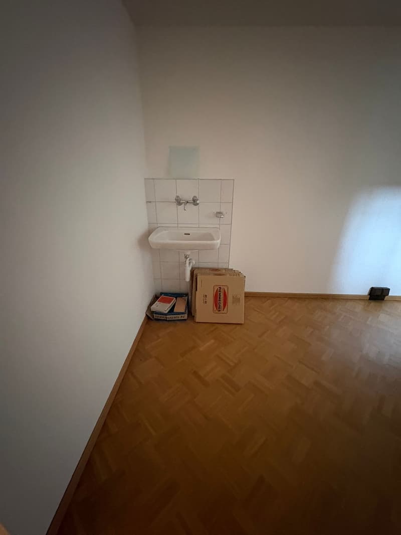 Empty room with sink, boxes and papers
