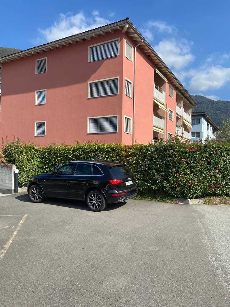 Apartment building with a black SUV parked in front
