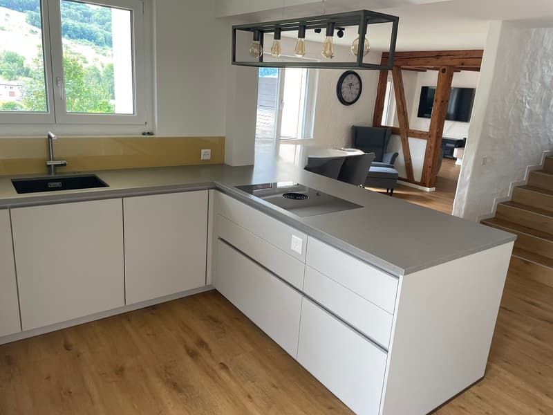 kitchen: modern kitchen with white cabinets, a stainless steel countertop, an island with an electric stove, modern faucet, large window