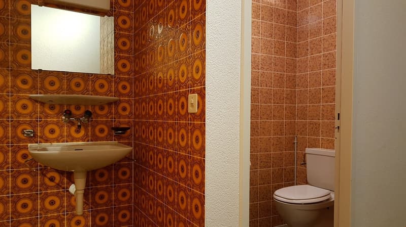 small bathroom with patterned tile, sink, mirror, toilet