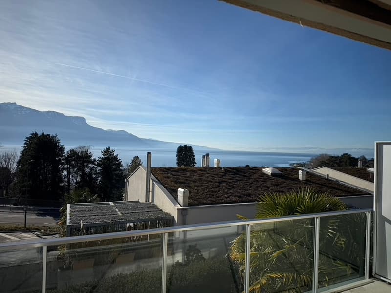 Balcony with glass railings, view of mountains and a body of water
