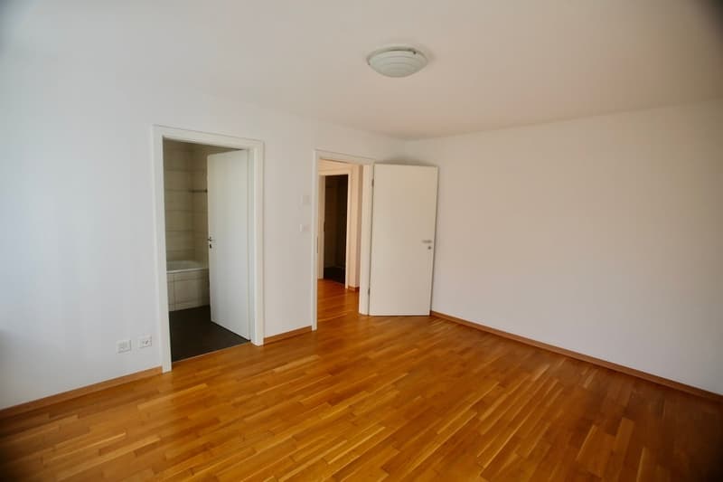 hardwood floor, white walls, two open doors, two rooms