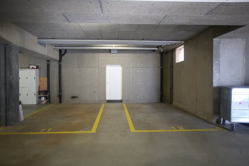 concrete walls, yellow parking lines, white door, metal storage box